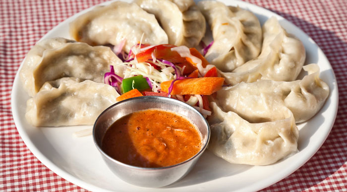 Nepalese traditional momos served with tomato chatni and fresh salad in restaurant